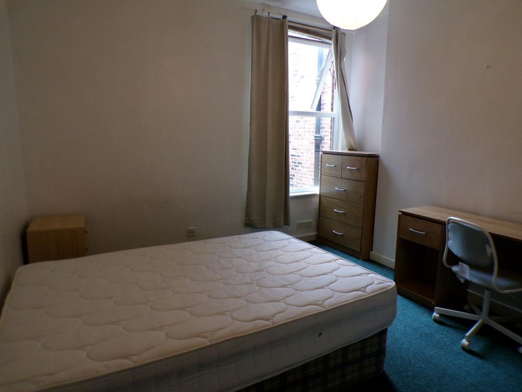 Bright, simply furnished bedroom with a large d...