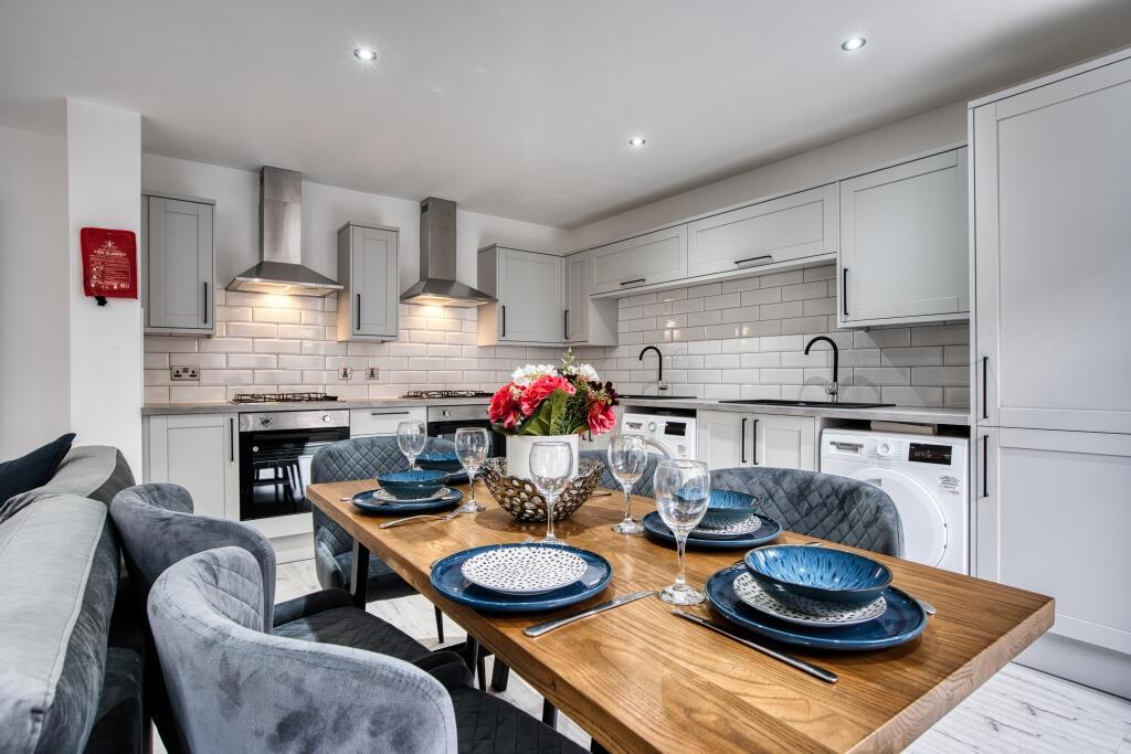 A modern and well-lit kitchen featuring clean s...