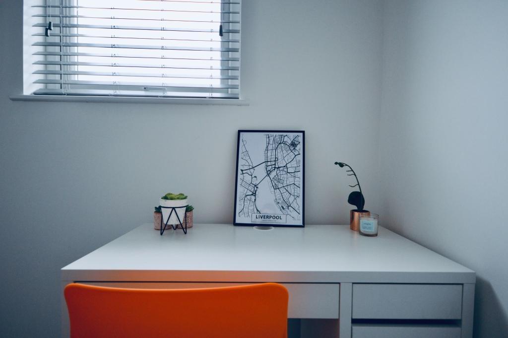 A bright and tidy study area with a white desk,...