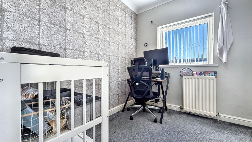 Neat single bedroom with a compact workspace by...