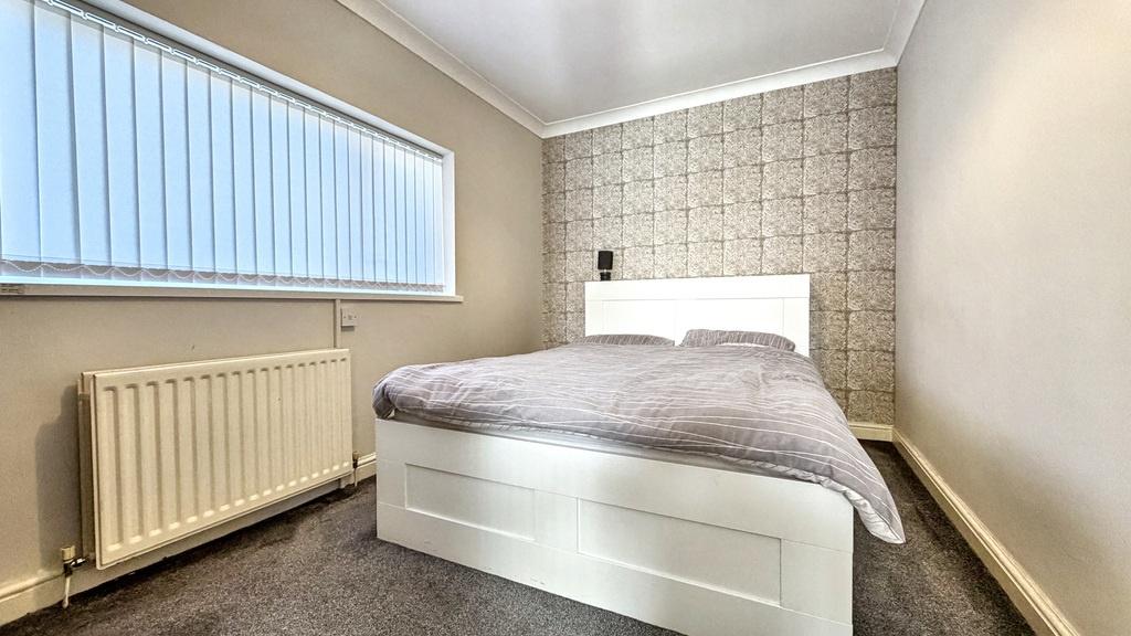 Bright, well-maintained bedroom with a comforta...
