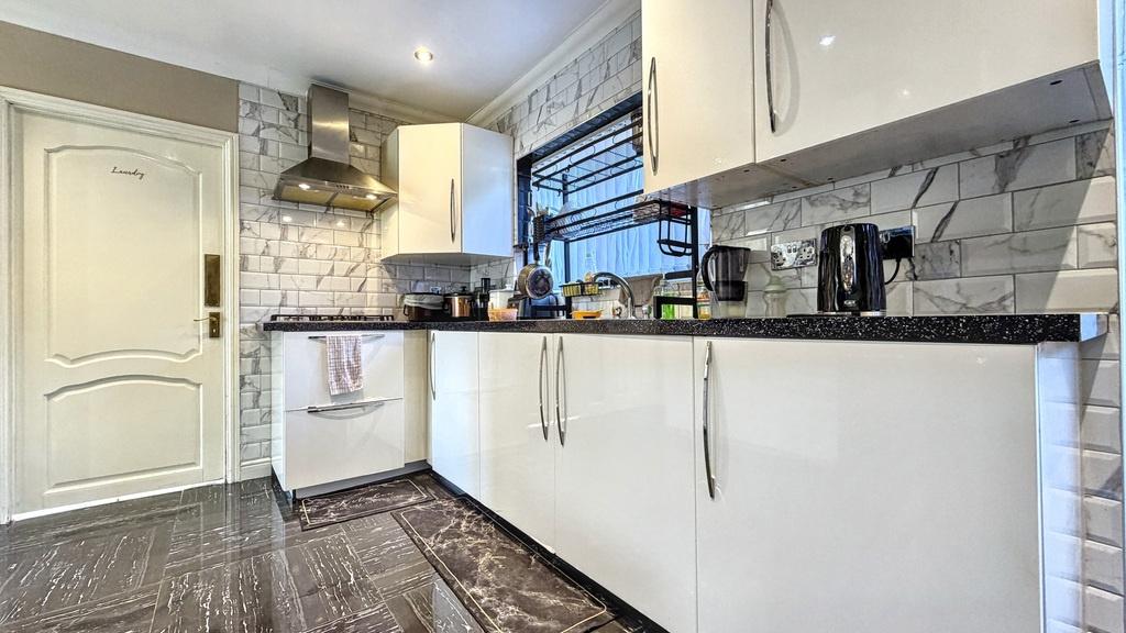 Bright, modern kitchen with glossy white cabine...