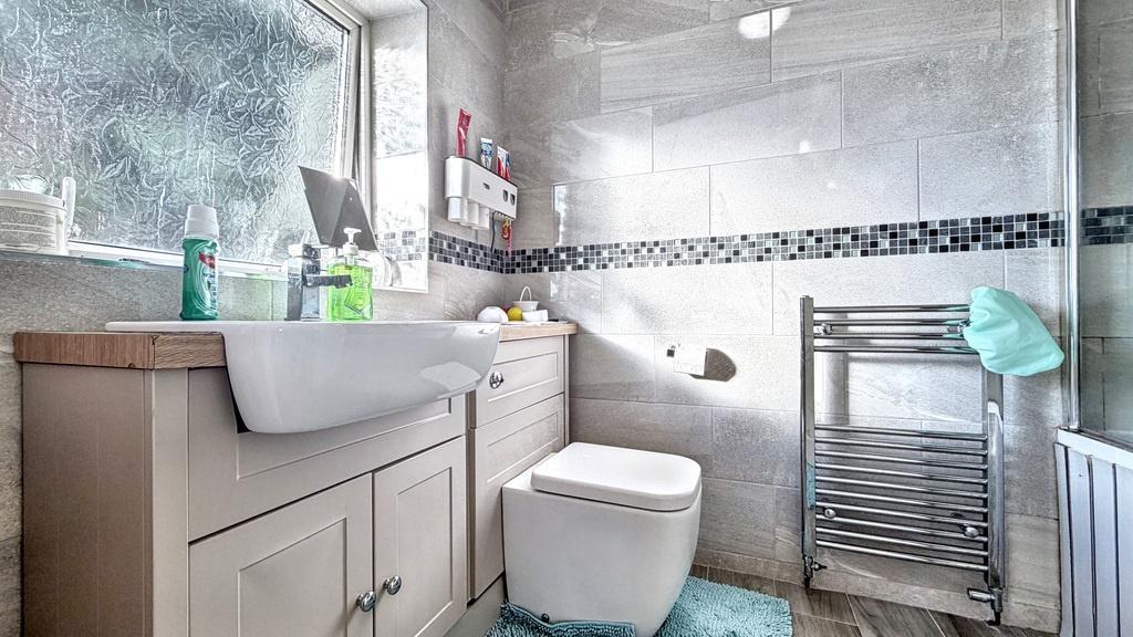 Bright modern bathroom with tiled walls, vanity...