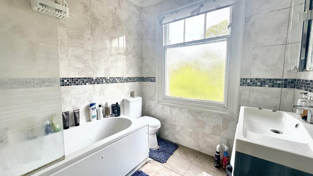 Bright, modern bathroom with a white bathtub, c...