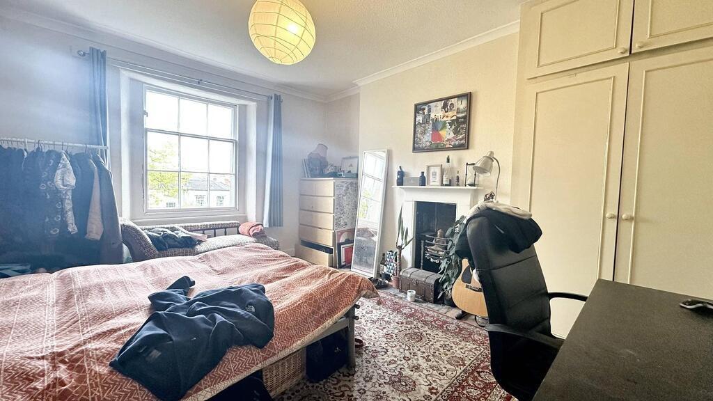 Bright double bedroom with a large window, buil...