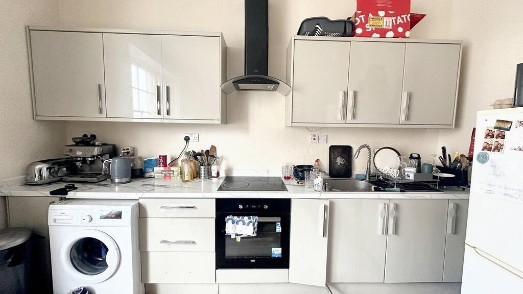 Bright, modern fitted kitchen with matching upp...