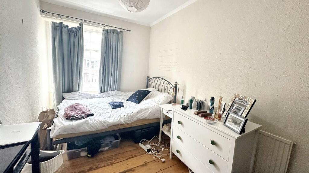 Bright, simply furnished bedroom with a large w...