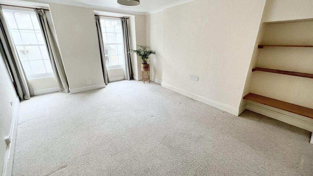 Bright, neutral living room with large bay wind...