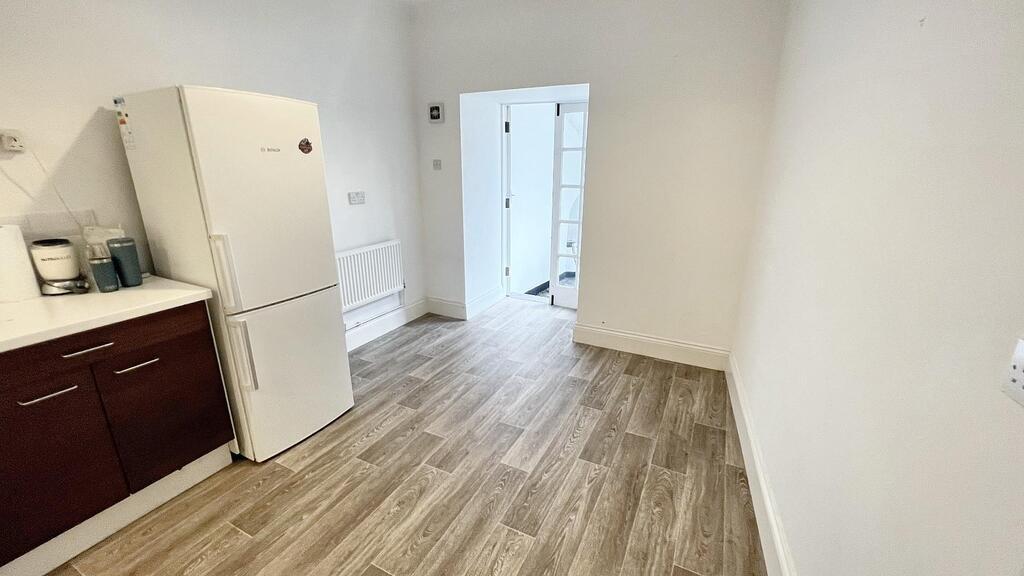 Bright, modern kitchen area with fresh white wa...