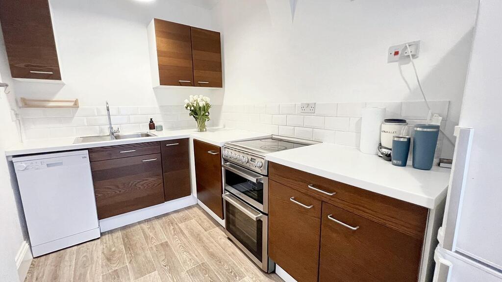 Bright modern kitchen with white worktops, wood...