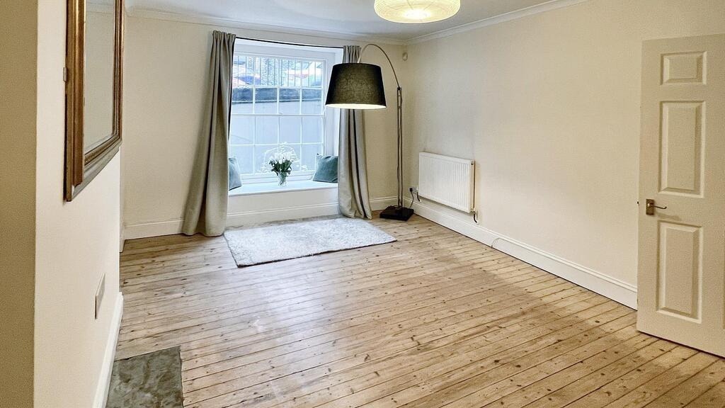 Bright, neutral living room with large window, ...