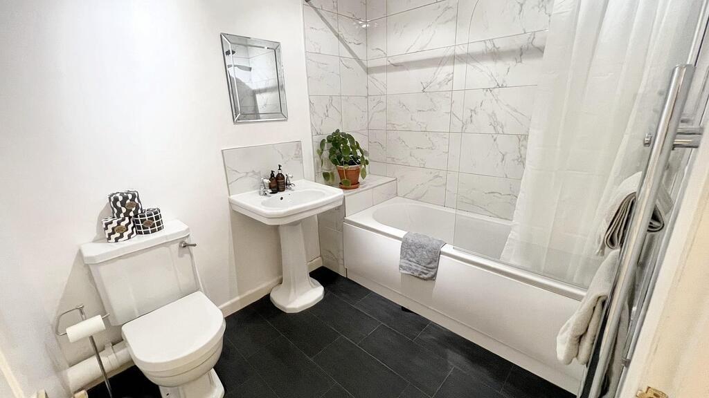 Bright, modern bathroom with a clean white suit...