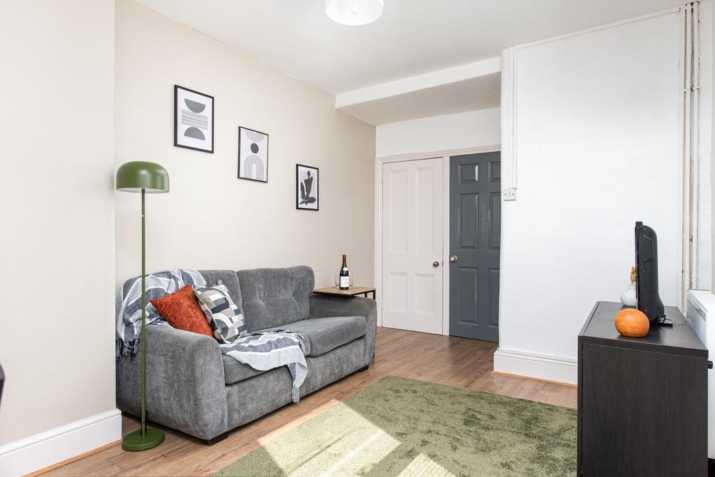 Bright, neatly presented living room with a com...