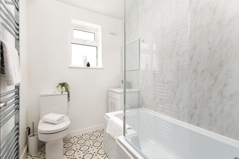 Bright, modern bathroom with a bathtub and show...