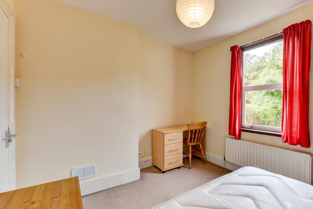 A bright and tidy bedroom with a large window d...