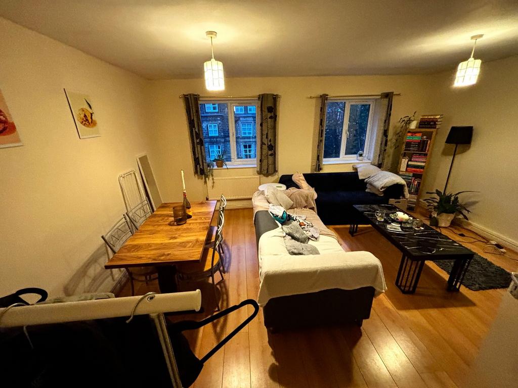 Warm, well-furnished living room with wooden fl...