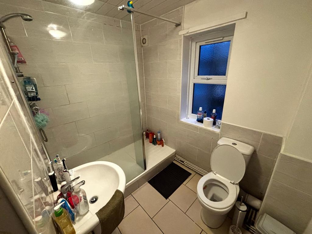 Bright, tiled bathroom with a walk-in shower an...