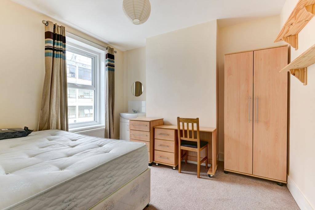 Bright single bedroom with a large window, neut...