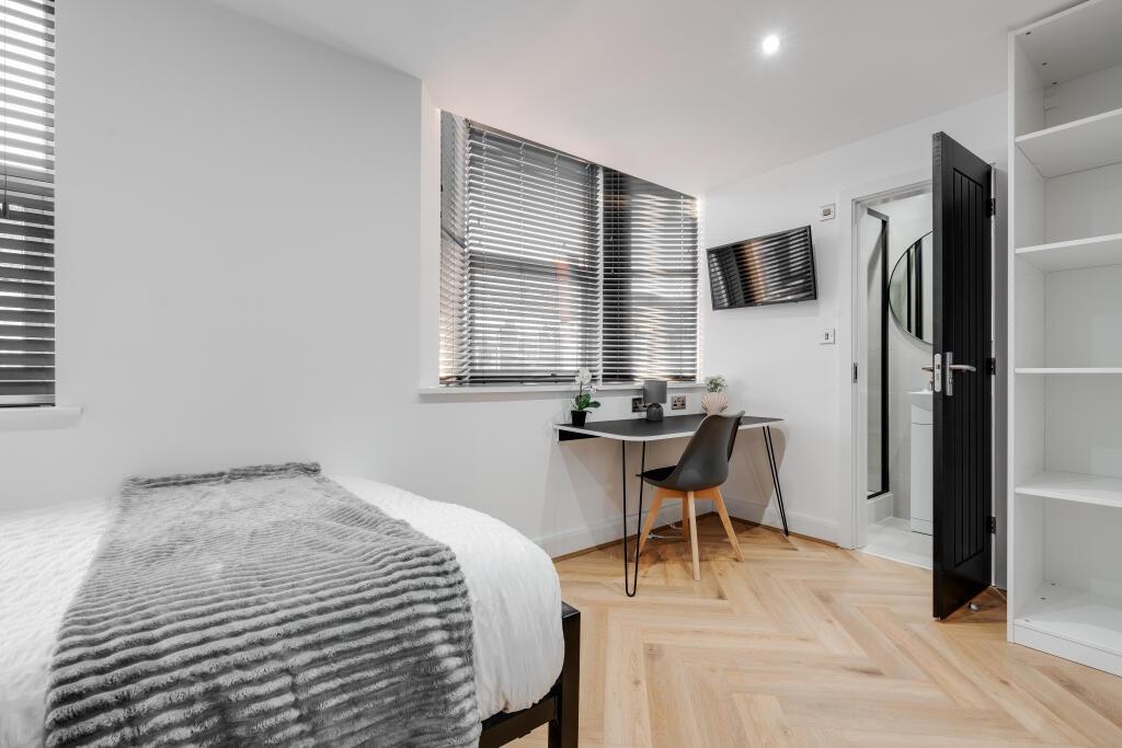 A bright and inviting bedroom featuring a comfo...