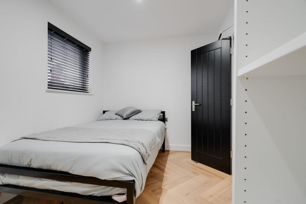 A cozy single bedroom featuring a neatly made b...