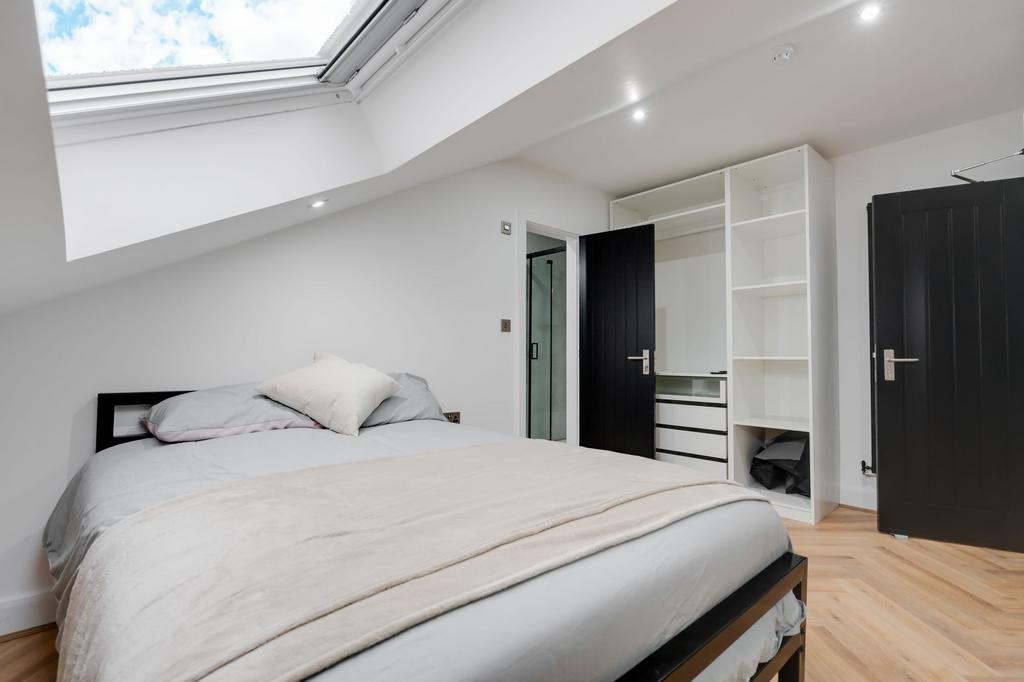 Bright and inviting bedroom with a skylight tha...