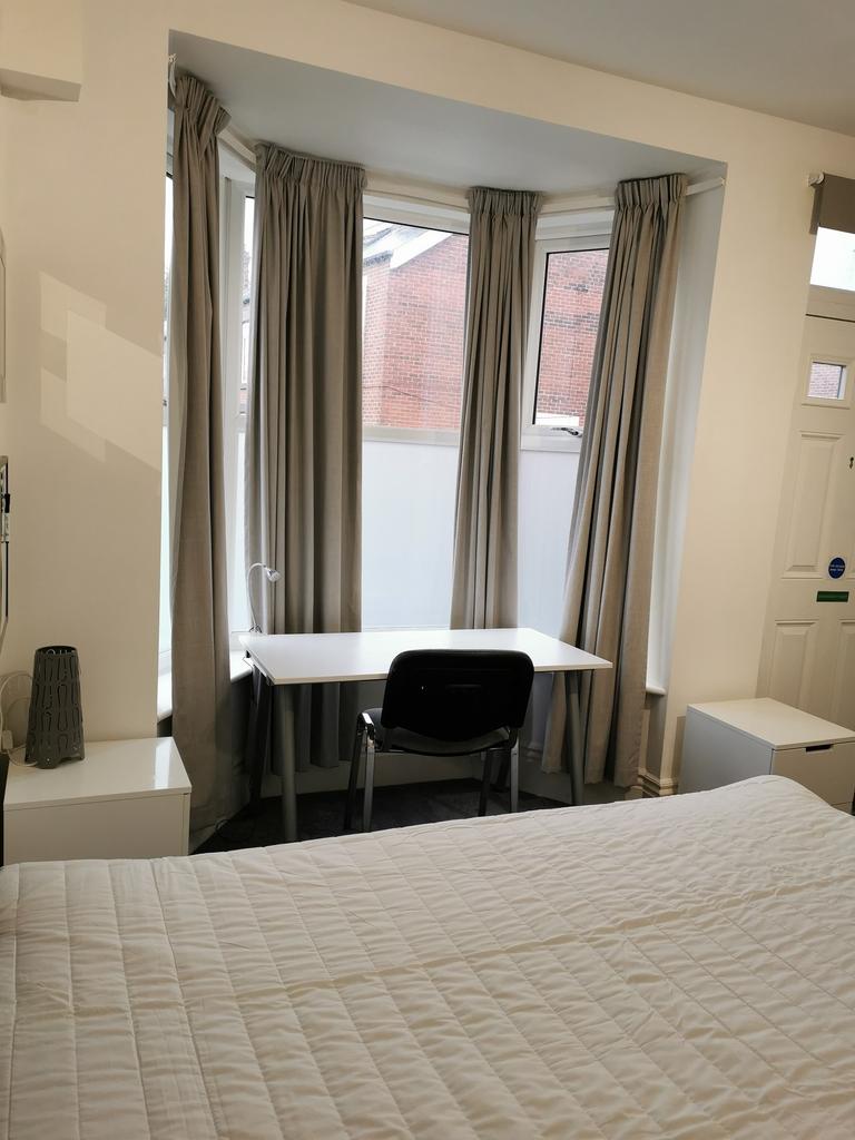 Bright, neatly presented bedroom with a large b...