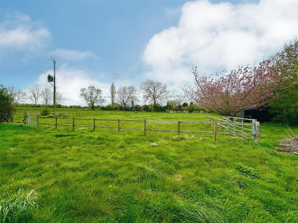 Paddocks with farmland beyond.jpg