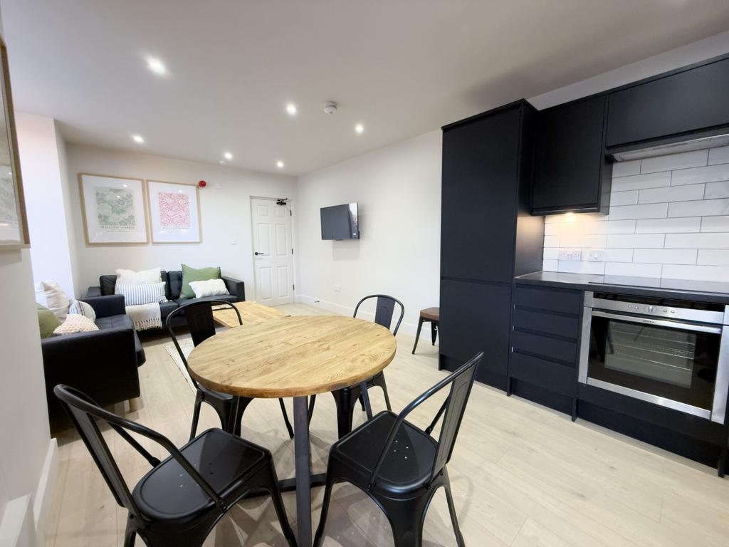Bright open-plan living area with a round dinin...