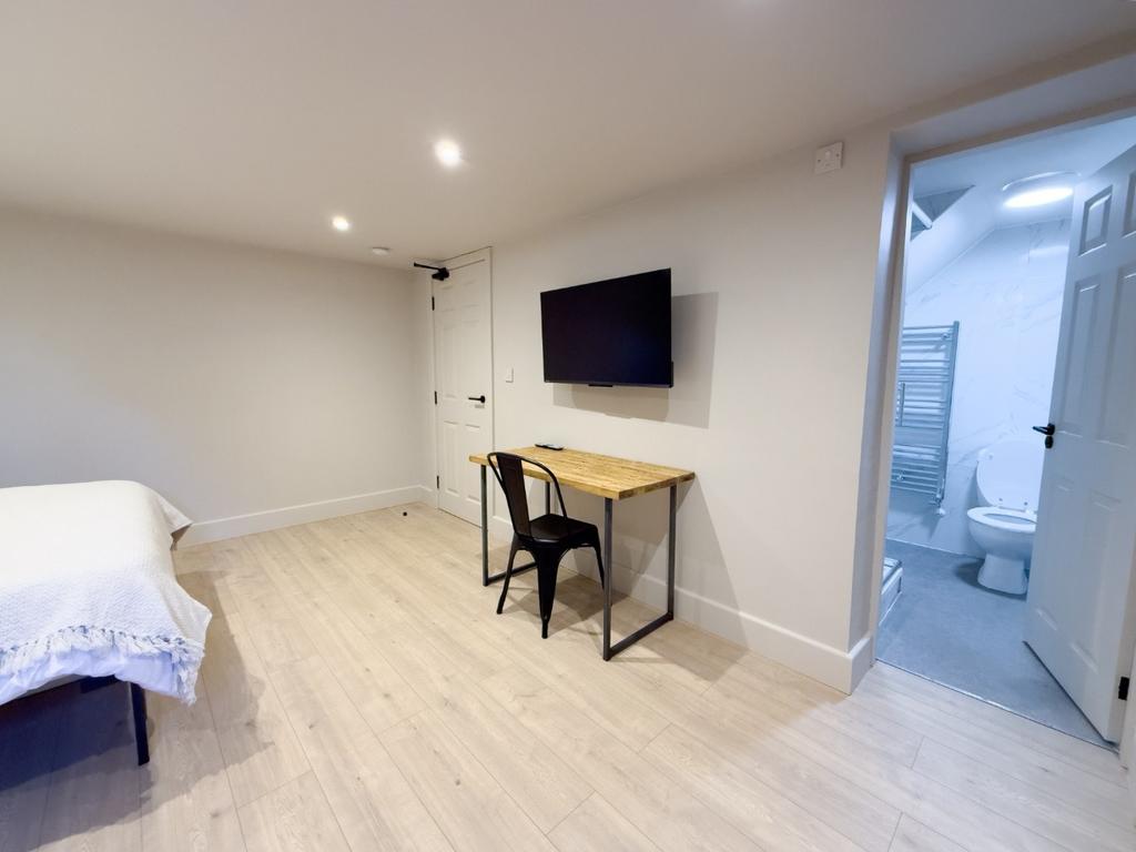 Bright, modern bedroom with light wood flooring...
