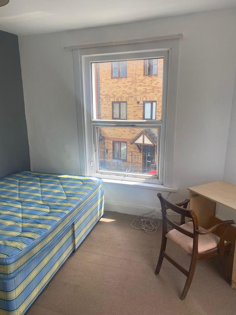 Bright single bedroom with a large sash window ...