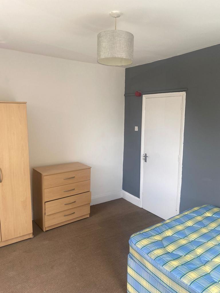 Bright, simply furnished bedroom with neutral d...