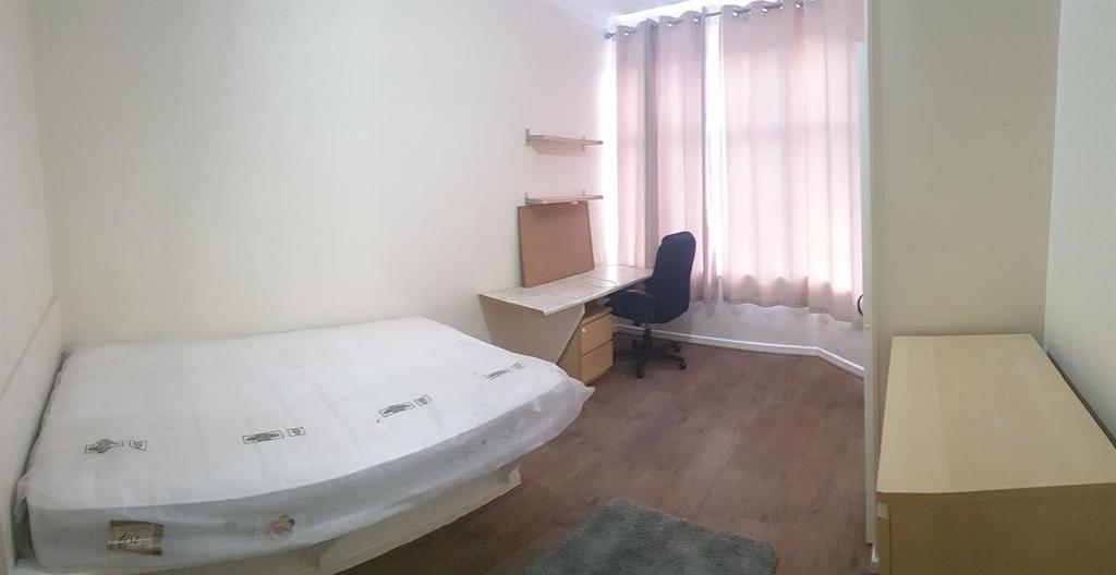 Bright, simply furnished bedroom with a double ...