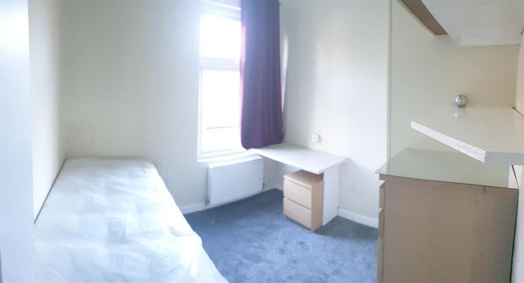 Bright single bedroom with a large window, fitt...