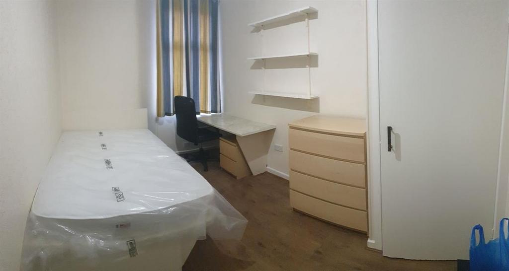 Bright, simply furnished single bedroom with a ...