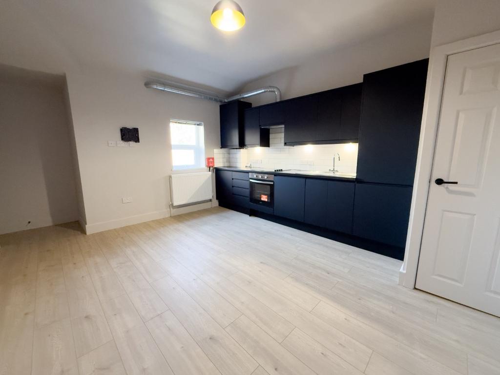 Modern open-plan kitchen with sleek dark cabine...
