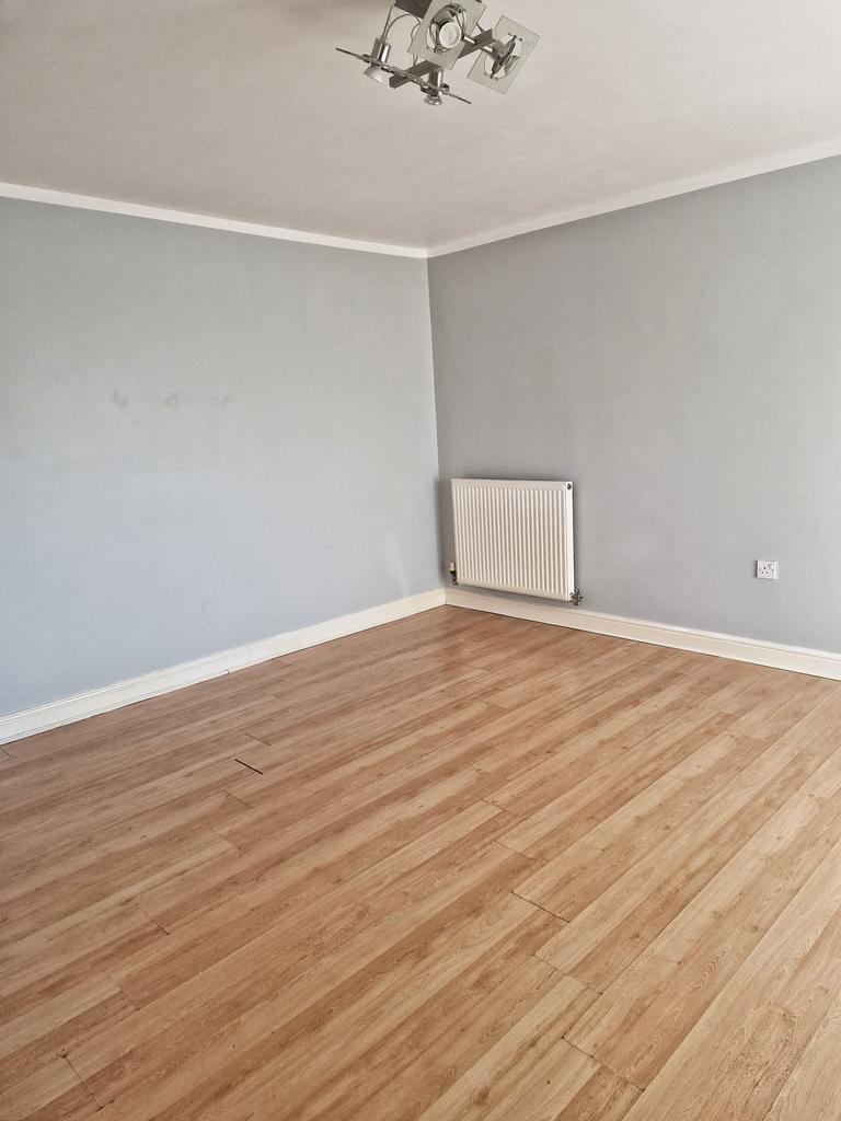Bright, neutral living room with pale grey wall...