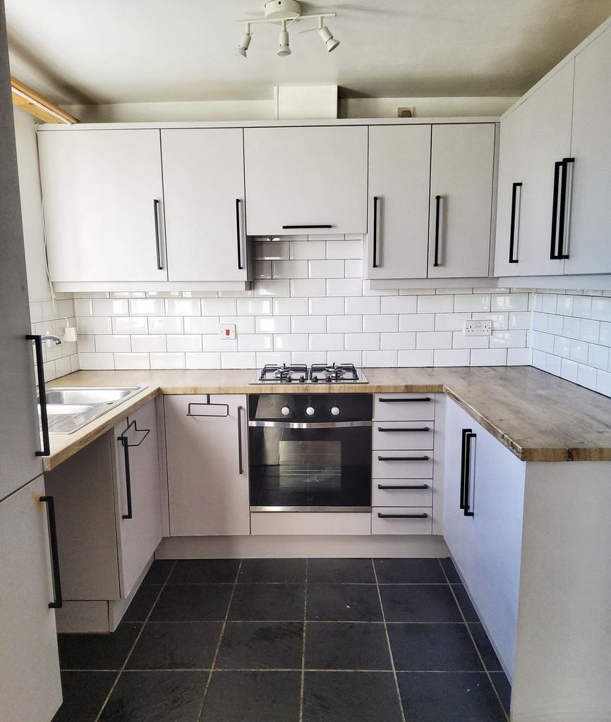 Bright, modern galley kitchen with white subway...