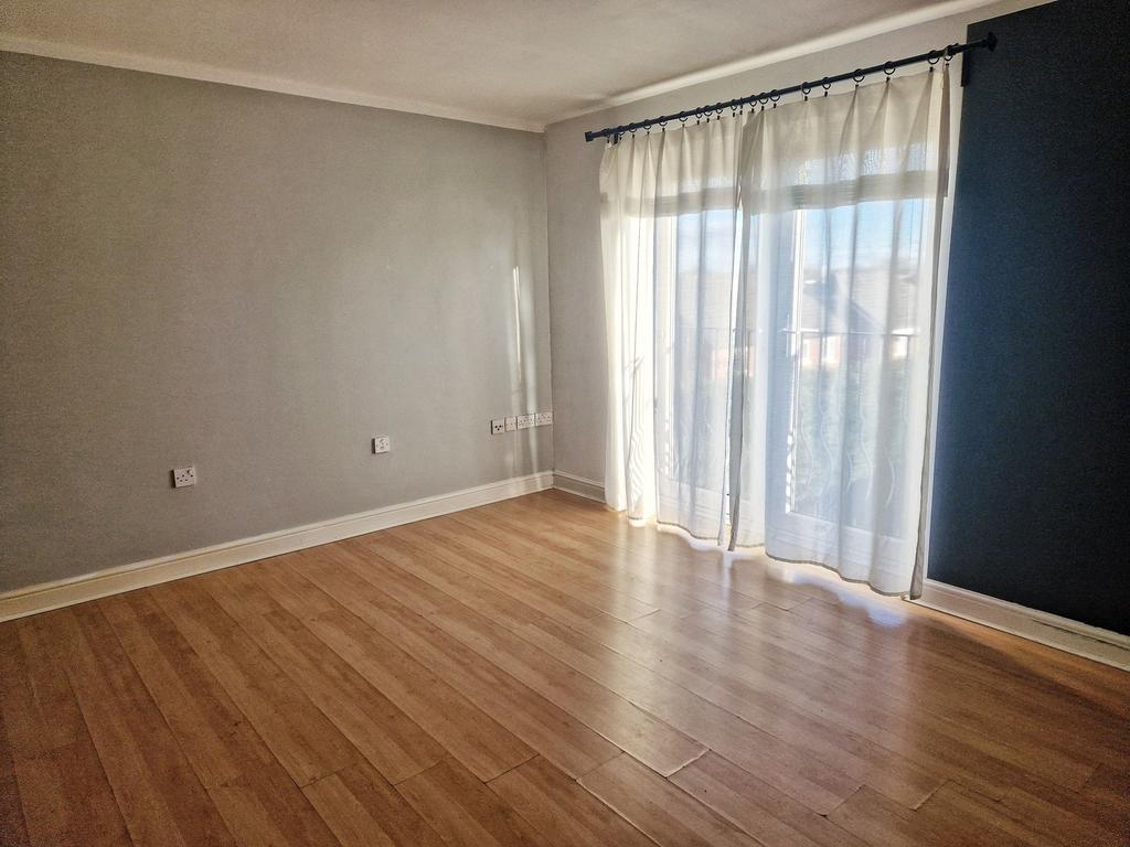 Bright, neutral bedroom with wood-effect floors...