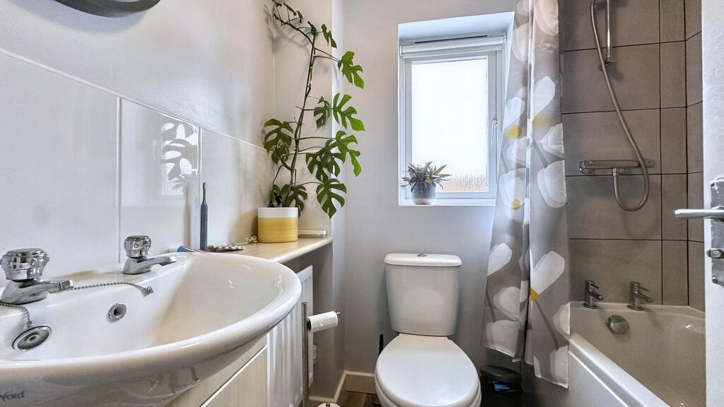 Bright, well-kept bathroom with a white sink an...