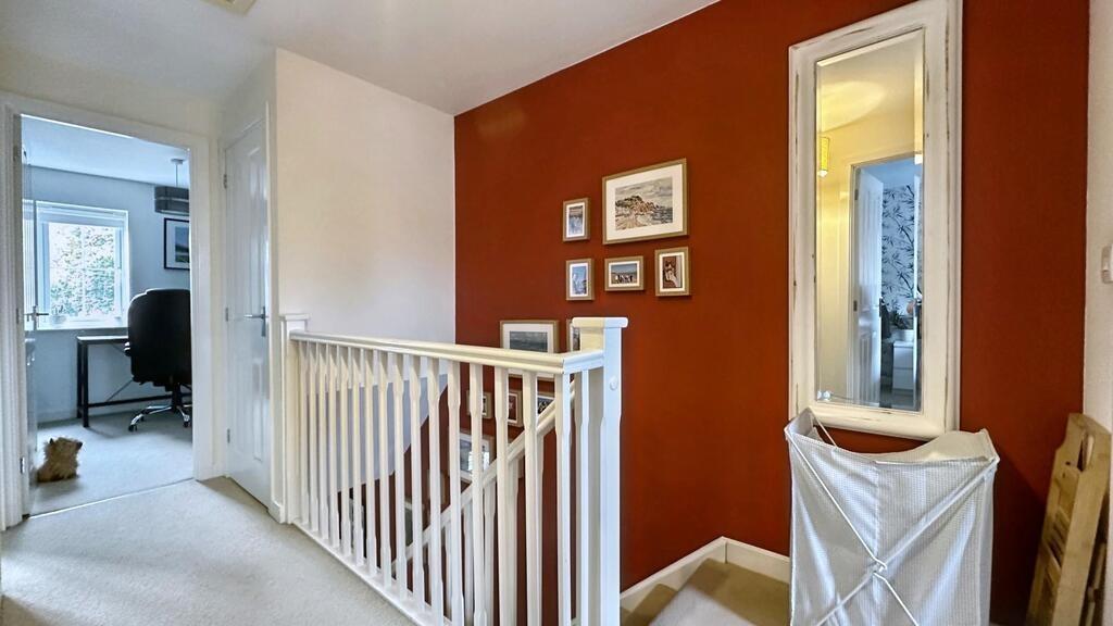 Bright first-floor landing with a white balustr...
