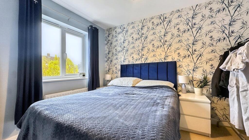 Bright, stylish bedroom with a navy upholstered...