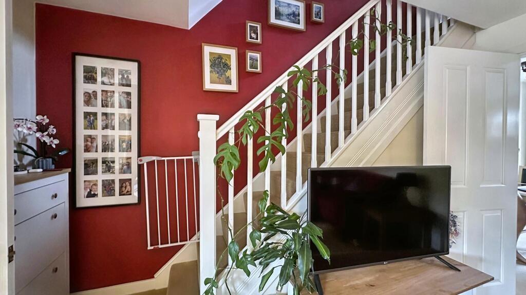 Bright, stylish living area with a bold red fea...