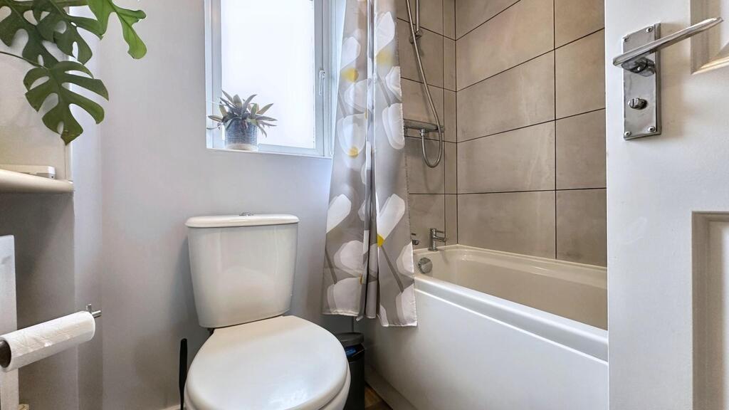 Bright, well-maintained bathroom featuring a ba...