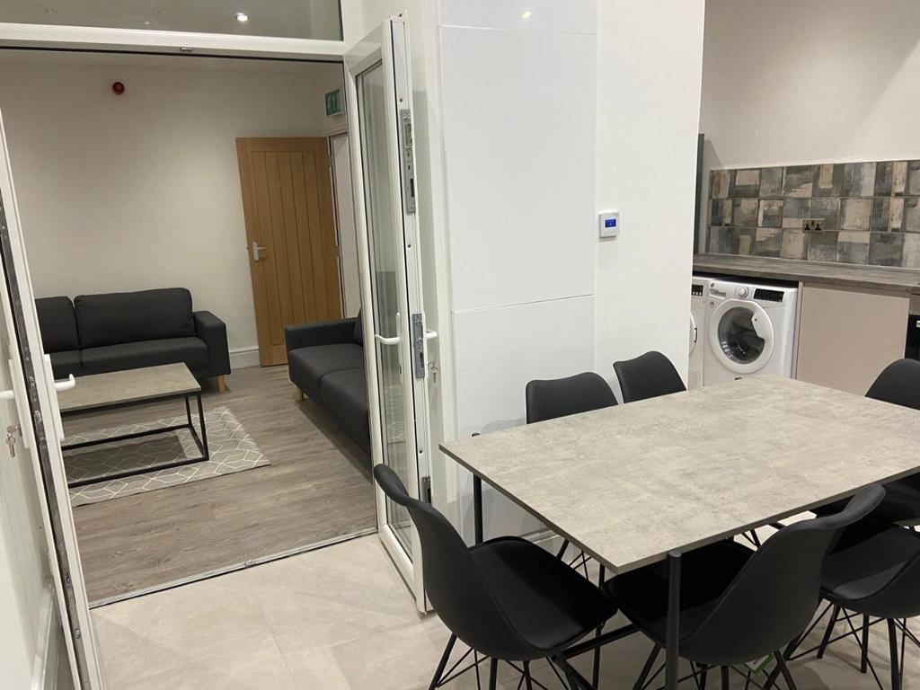 Bright, modern communal lounge with a dining ta...