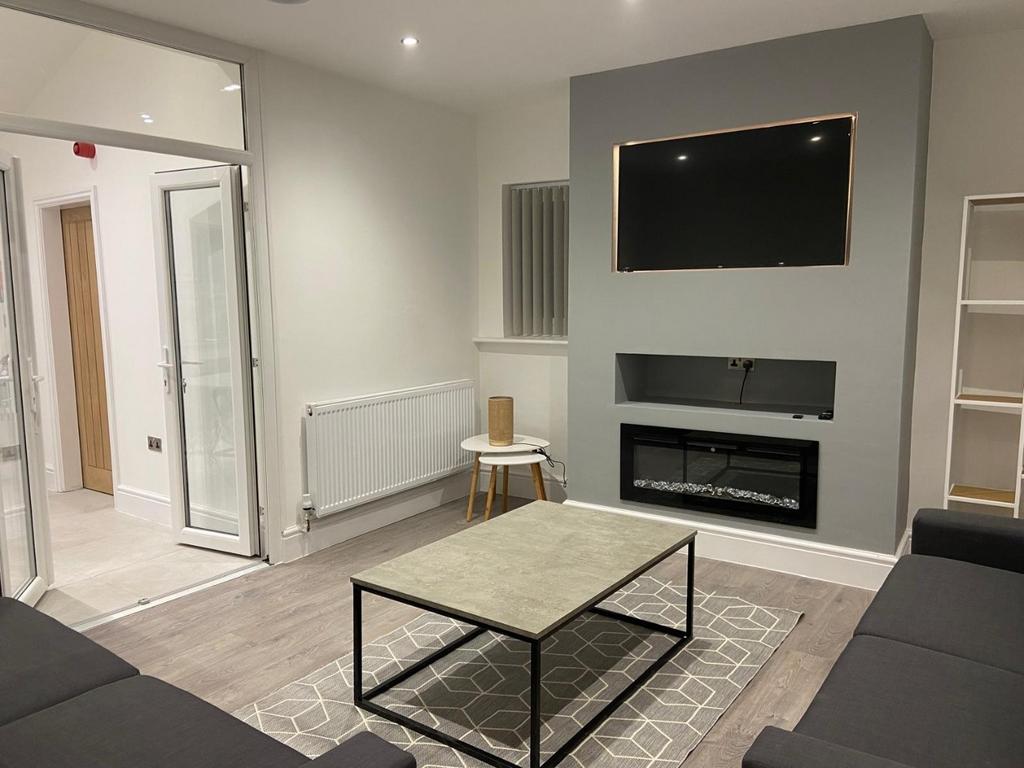 Contemporary living room with a wall-mounted TV...