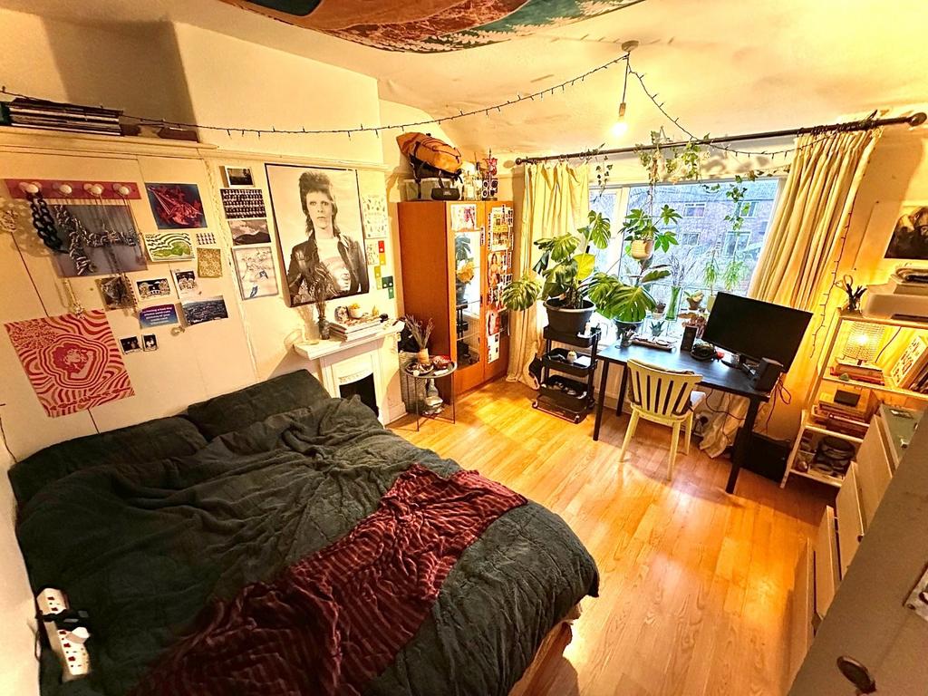 Bright, cozy bedroom with large window, abundan...