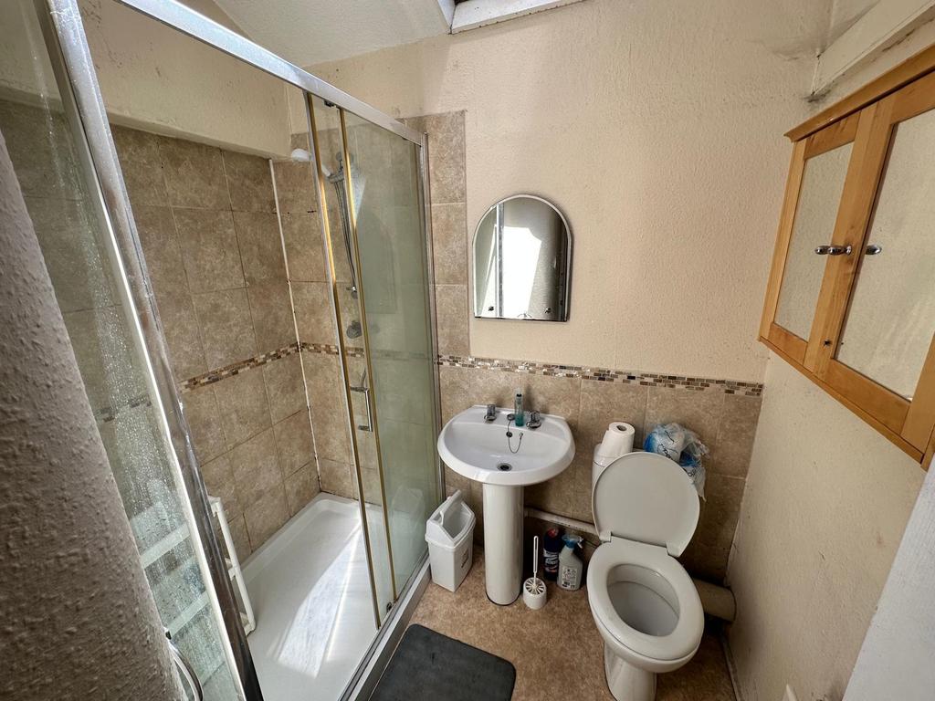 Bright tiled bathroom with a glass-enclosed sho...