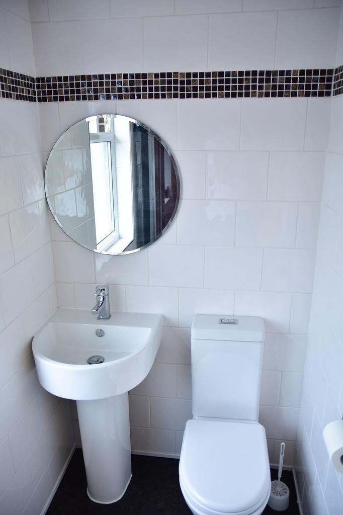 A modern, clean bathroom featuring a white sink...