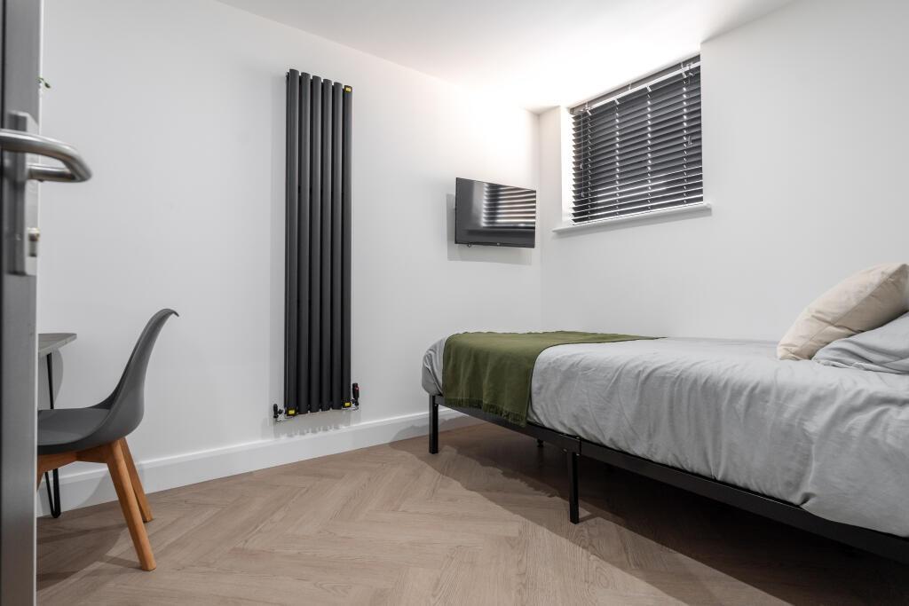 Bright and modern bedroom featuring a comfortab...