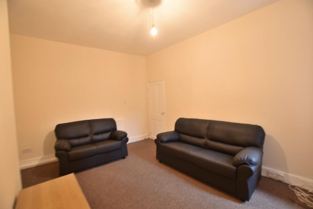 Bright, neutral living room with two black leat...